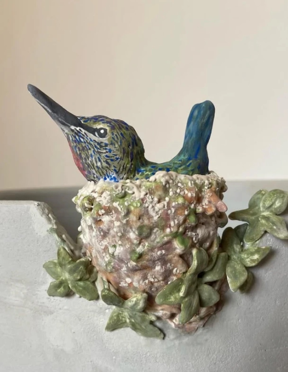 Beija-flor de cerâmica pintado à mão num ninho
