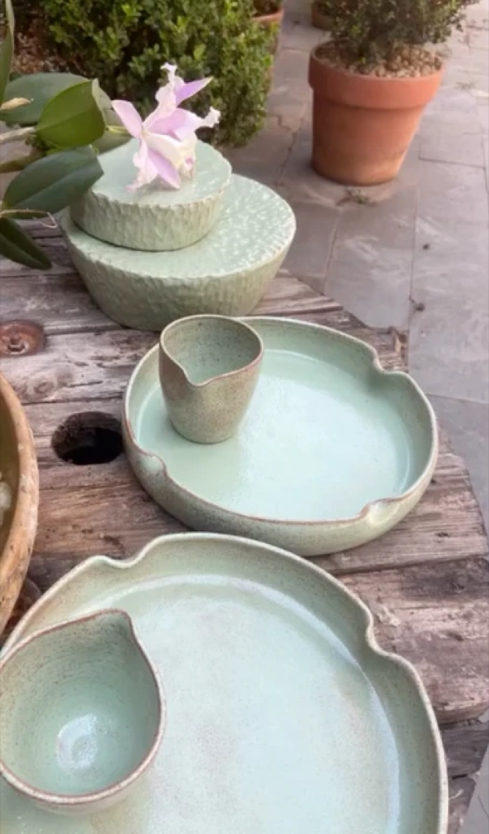 Pratos e jarrinhas em celadon sobre mesa de madeira